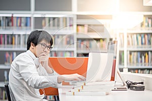 Young Asian man university student working in library