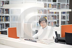 Young Asian man university student working in library