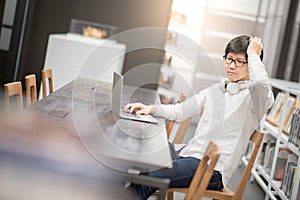 Young Asian man university student working in library