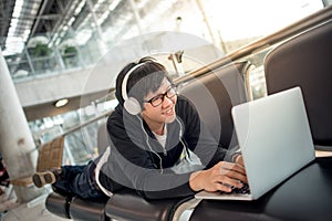 Young man listening to music waiting in airport terminal