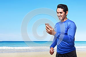 Young asian man using mobile phone before going for a run