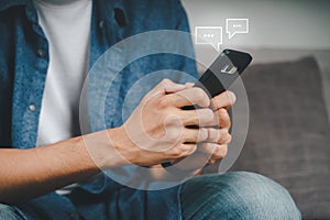 Young Asian man using smartphone typing, chatting conversation with pop up chat box icons. Social Network, technology concept