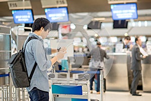 Young asian man waiting for airport check in