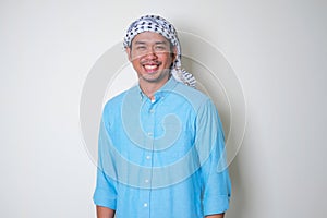 Young Asian man wearing Arabian Shemagh head scarf smiling friendly