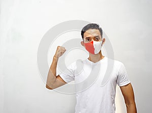 Young asian man wearing red and white mask, he was clenched his hand. Isolated on white background