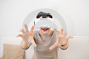 Young asian man wearing virtual reality glasses in modern interior design coworking studio. Smartphone using with VR goggles head