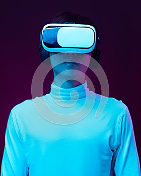 Young asian man wearing virtual reality goggles watching 360 degree video in neon light  Technology concept.
