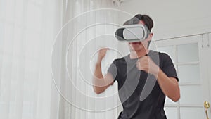 Young asian man wearing vr headset while workout and exercise at living room, futuristic and innovation of virtual reality.