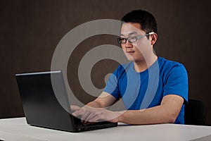 Young asian man working on his laptop computer