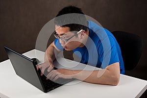 Young asian man working on his laptop computer