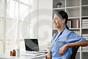 Young Asian medical student smiling and sitting in the study room