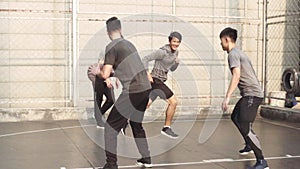 Young asian men having fun playing basketball on outdoor court