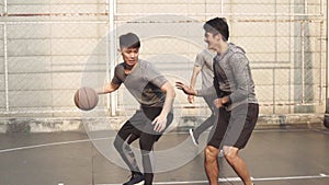 Young asian men having fun playing basketball on outdoor court