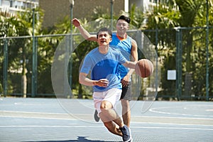 Young asian men playing basketball