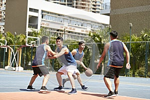 Young asian men playing basketball