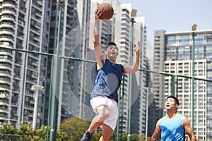 Young asian men playing basketball