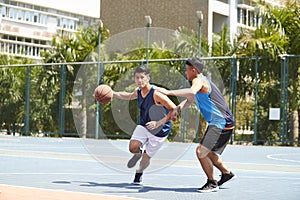 Young asian men playing basketball