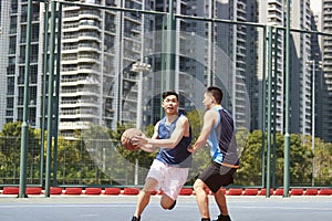 Young asian men playing basketball