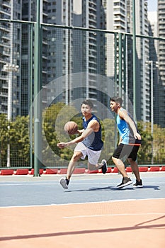 Young asian men playing basketball