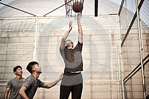 Young asian men playing basketball outdoors