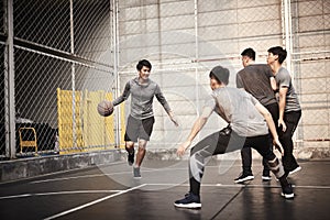 Young asian men playing basketball outdoors