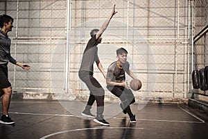 Young asian men playing basketball outdoors