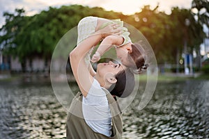 Young asian mother with a cute daughter is relaxing and happy in the park