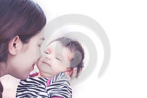 Young asian mother hugging and kissing her newborn baby girl