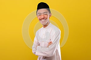 Young Asian Muslim man stand and pose in front of the camera with friendly smile