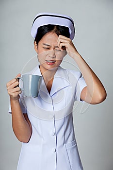 Young Asian nurse got headache with a cup of coffee