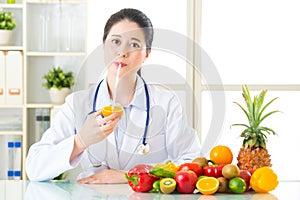 Young asian nutritionist drinking orange juice