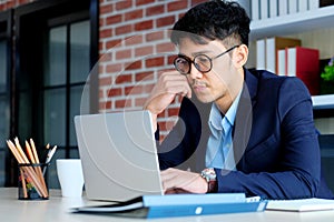 Young asian office man struggle with laptop computer, Frustrated asian business man looking at computer while working at office,