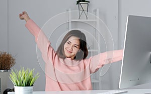 Young asian office woman stretching body for relaxing while working with computer at her desk, office lifestyle, business