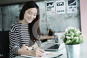 Young asian office woman working with laptop computer at desk of