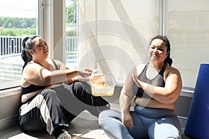 Young Asian overweight women refuse and say no potato chips after exercising in fitness sports club