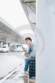 Young asian passenger waiting for taxi at the airport
