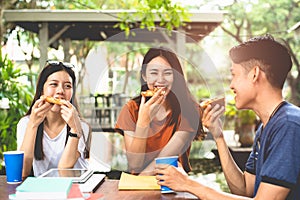 Young Asian people eating pizza together by hands. Food and Friendship celebration party concept. Lifestyles and people in theme.