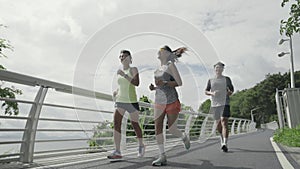 young asian people running jogging outdoors in park by the sea