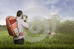 Young asian photographer with backpack taking