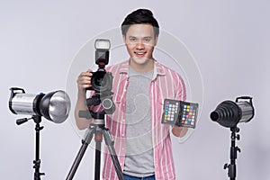 Young asian photographer holding digital camera, while working i