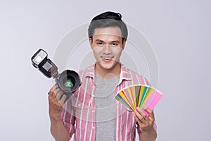 Young asian photographer holding digital camera, while working i