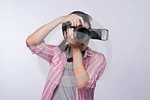 Young asian photographer holding digital camera, while working i