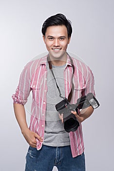 Young asian photographer holding digital camera, while working i