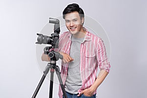 Young asian photographer holding digital camera, while working i