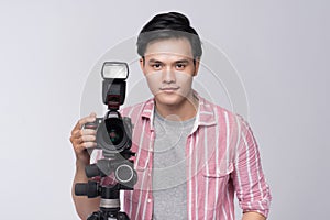 Young asian photographer holding digital camera, while working i