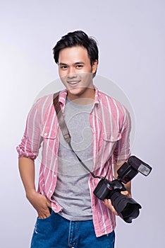 Young asian photographer holding digital camera, while working i