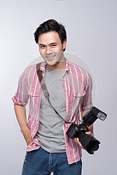 Young asian photographer holding digital camera, while working i