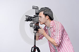 Young asian photographer holding digital camera, while working i