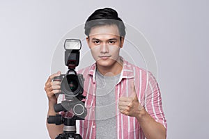 Young asian photographer holding digital camera, while working i