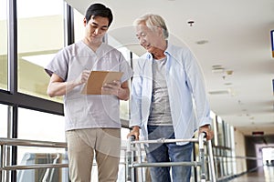 Young asian physical therapist working with old man